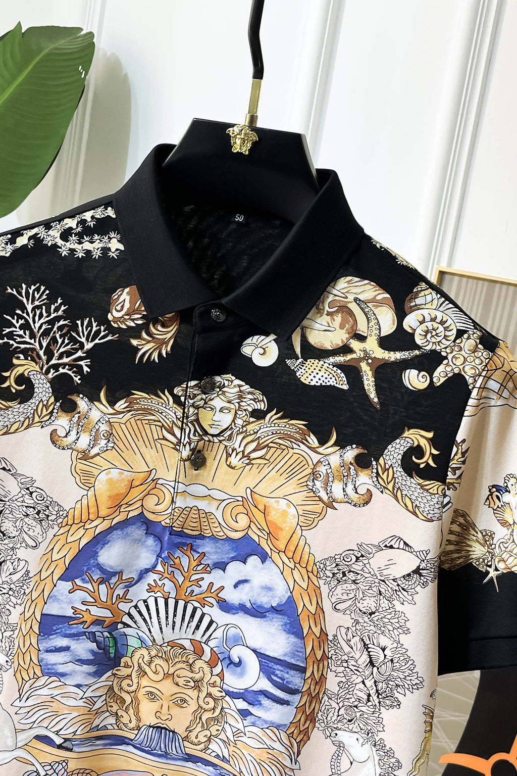 Versace short-sleeve polo shirt close view of black collar and blue, gold portrait print