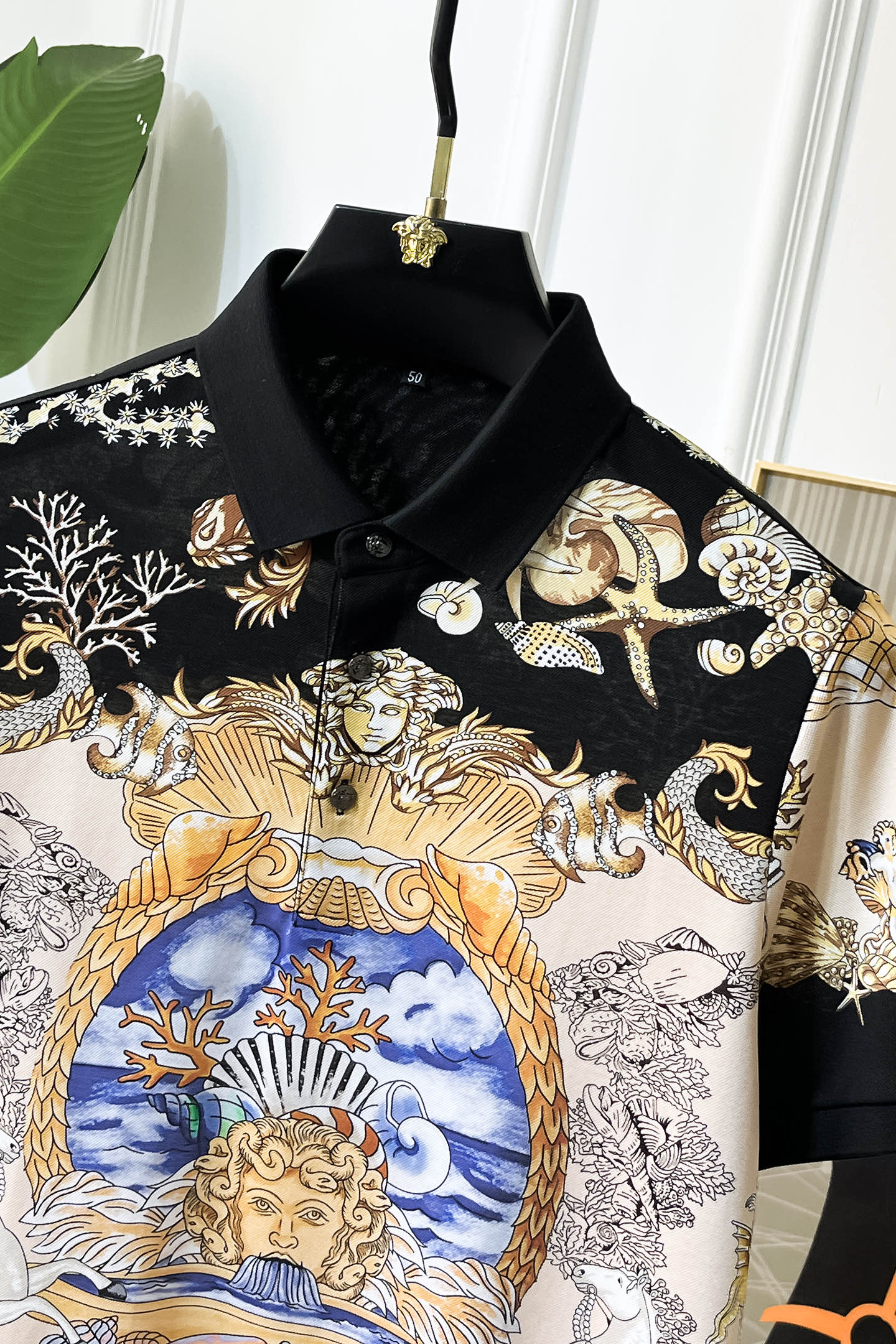 Versace short-sleeve polo shirt close view of black collar and blue, gold portrait print