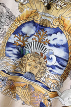 Versace polo shirt fabric detail with blue sky face and gold ornamental baroque lines