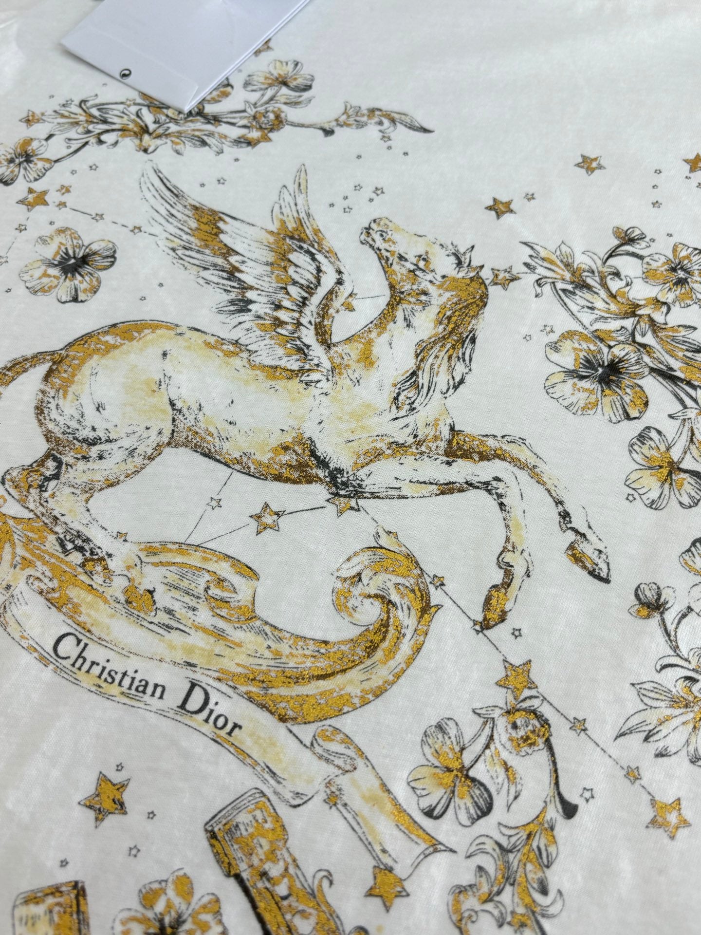 Dior short-sleeve T-shirt close-up of gold horse graphic with stars and flowers