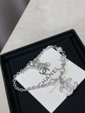 Silver charm bracelet with pearl beads and star, flower, and CC logo charms