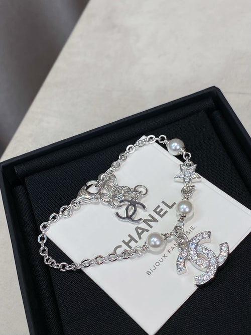 Silver charm bracelet with pearl beads and star, flower, and CC logo charms