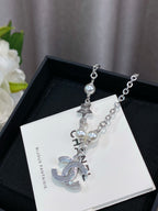 Silver charm bracelet with pearl beads and CHANEL-style letter charms on card
