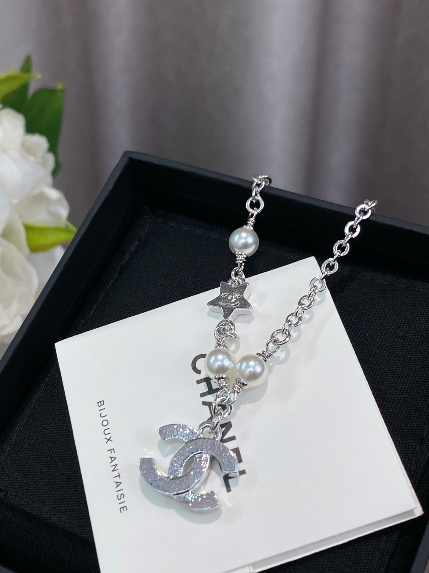 Silver charm bracelet with pearl beads and CHANEL-style letter charms on card