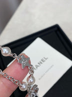 Close-up of pearl bead silver charm bracelet with cat charm pendant