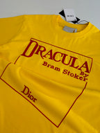 Yellow short-sleeve T-shirt detail of “DRACULA” logo graphic and “Dior” text.