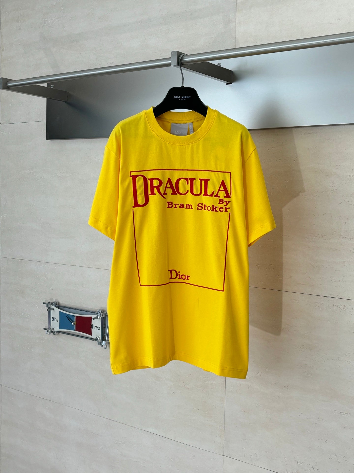 Yellow Dior short-sleeve T-shirt with “DRACULA” graphic print on front.