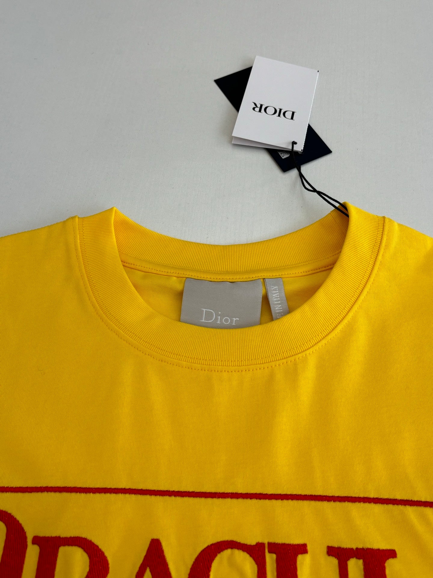 Yellow crew-neck T-shirt with interior neck label and size tag.