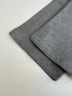Gray T-shirt fabric folds showing sleeve length and smooth knit texture