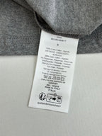 Gray T-shirt care label on inside neck with size and composition text