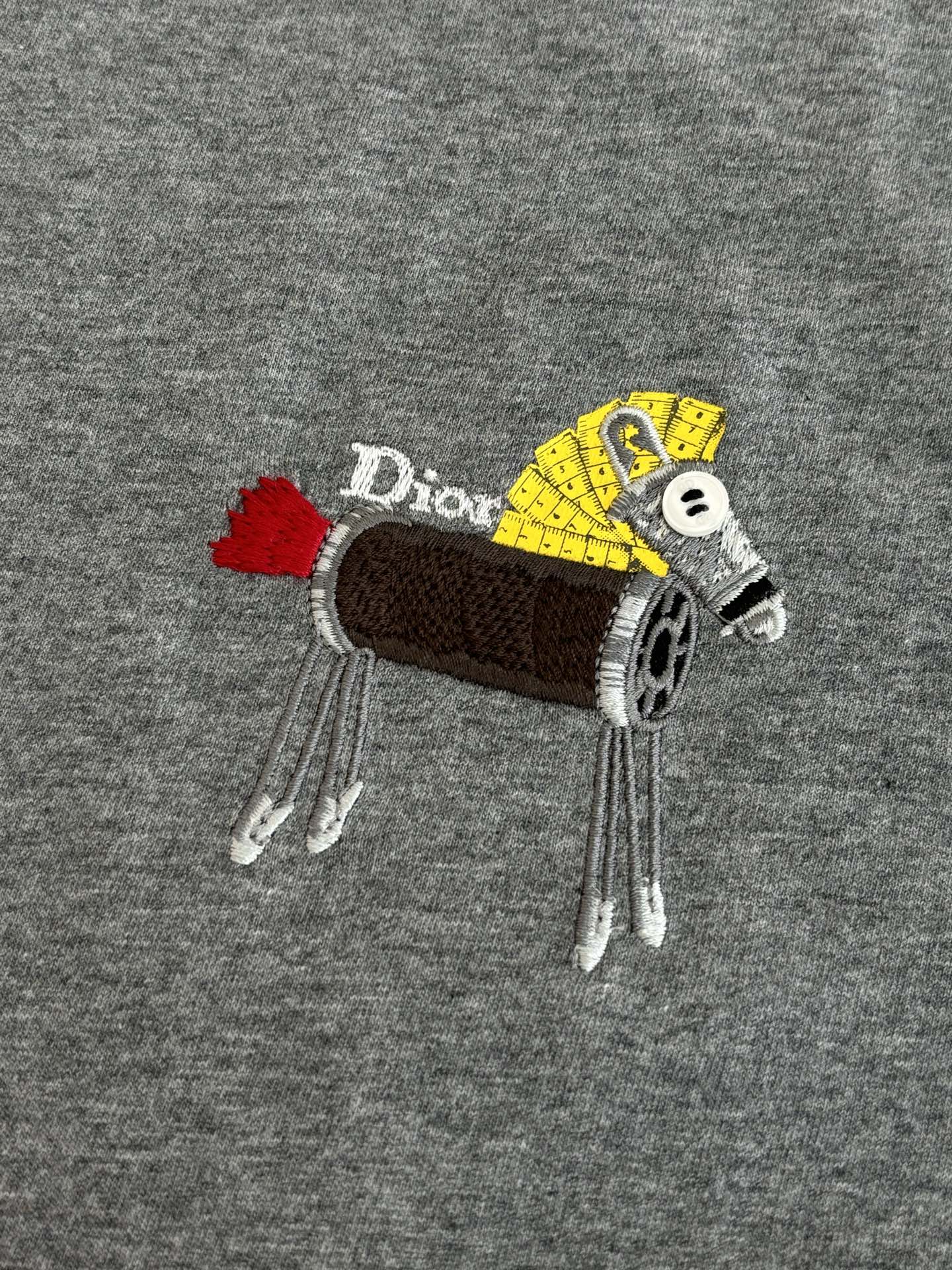 Gray T-shirt with large embroidered cartoon patch logo on chest