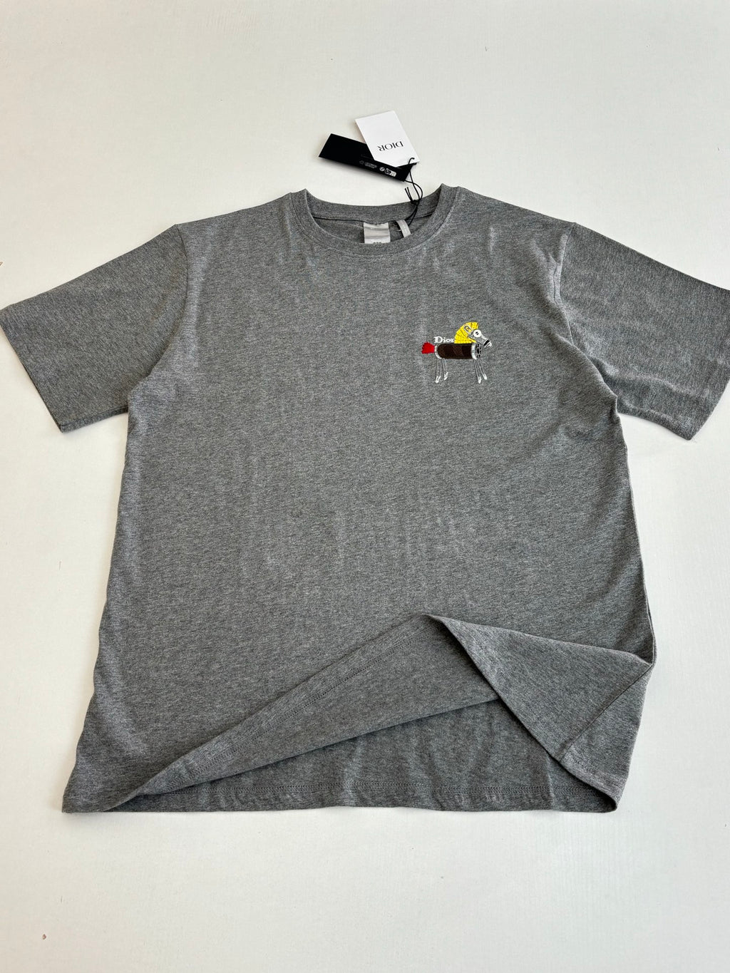 Gray short-sleeve T-shirt with cartoon patch logo on chest, folded lay