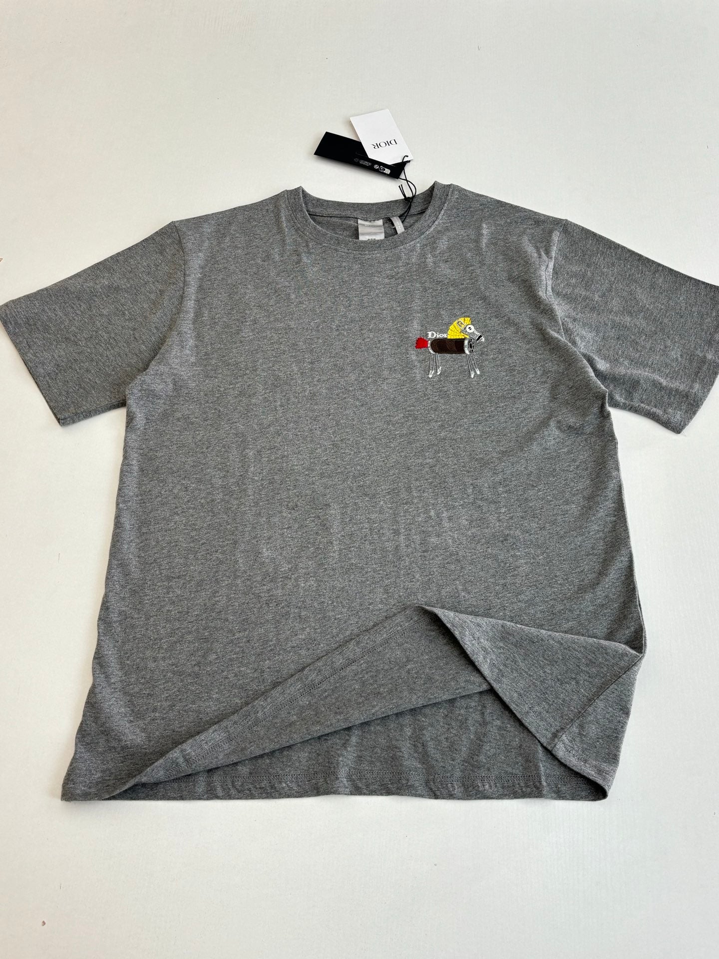 Gray short-sleeve T-shirt with cartoon patch logo on chest, folded lay