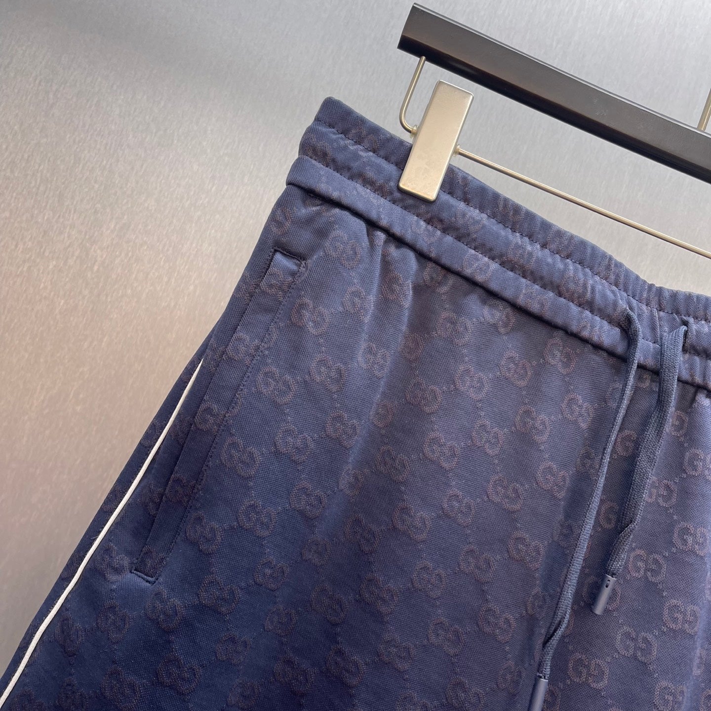 Gucci shorts close-up showing elastic waistband and drawstring with GG logo pattern