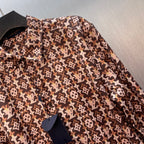 Long-sleeve button-up shirt with brown-and-cream monogram pattern, button details