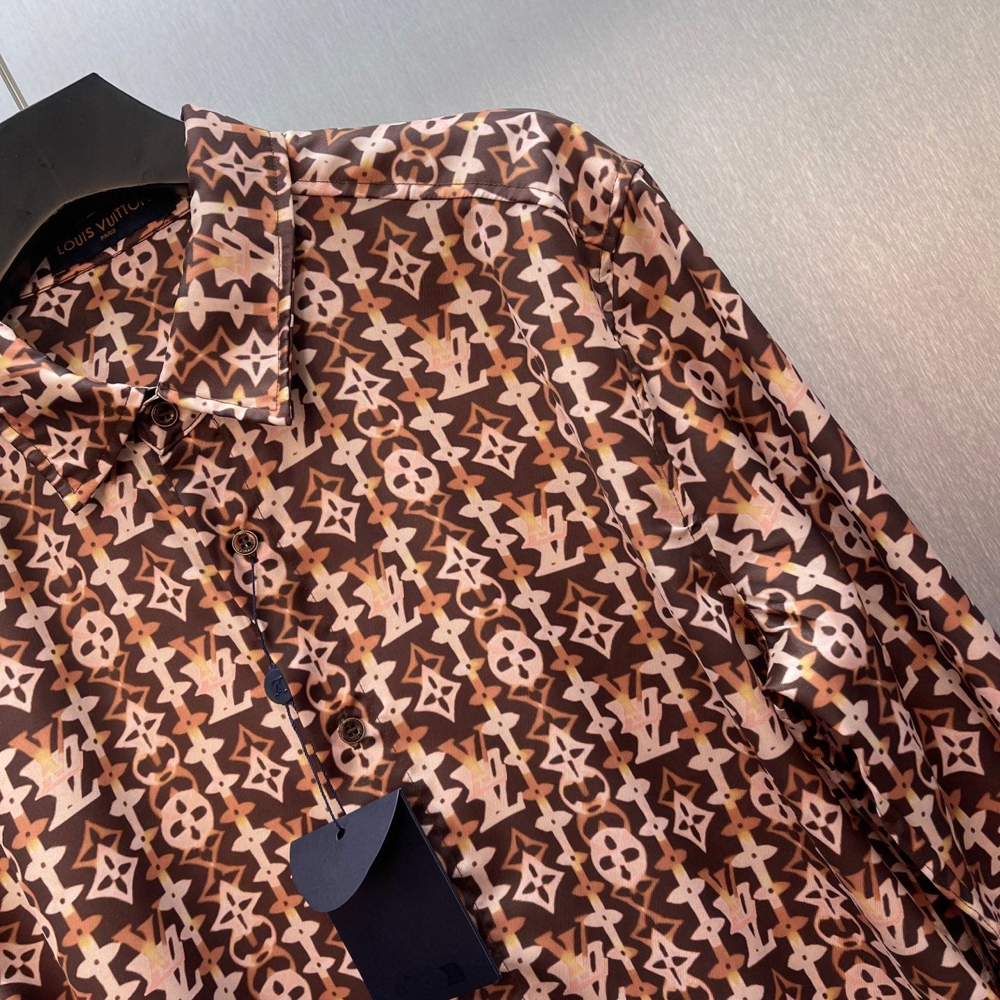 Long-sleeve button-up shirt with brown-and-cream monogram pattern, button details