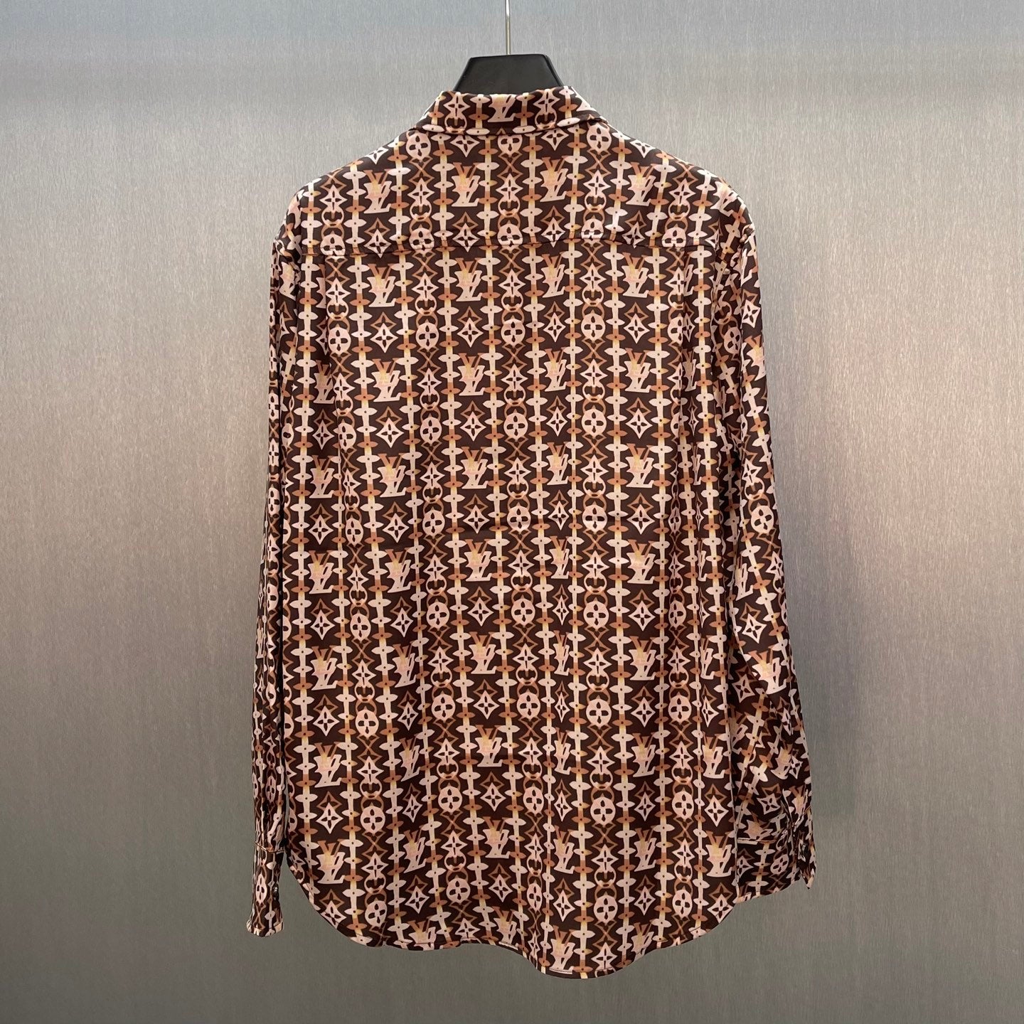 Long-sleeve button-up shirt with brown-and-cream monogram pattern, curved hem