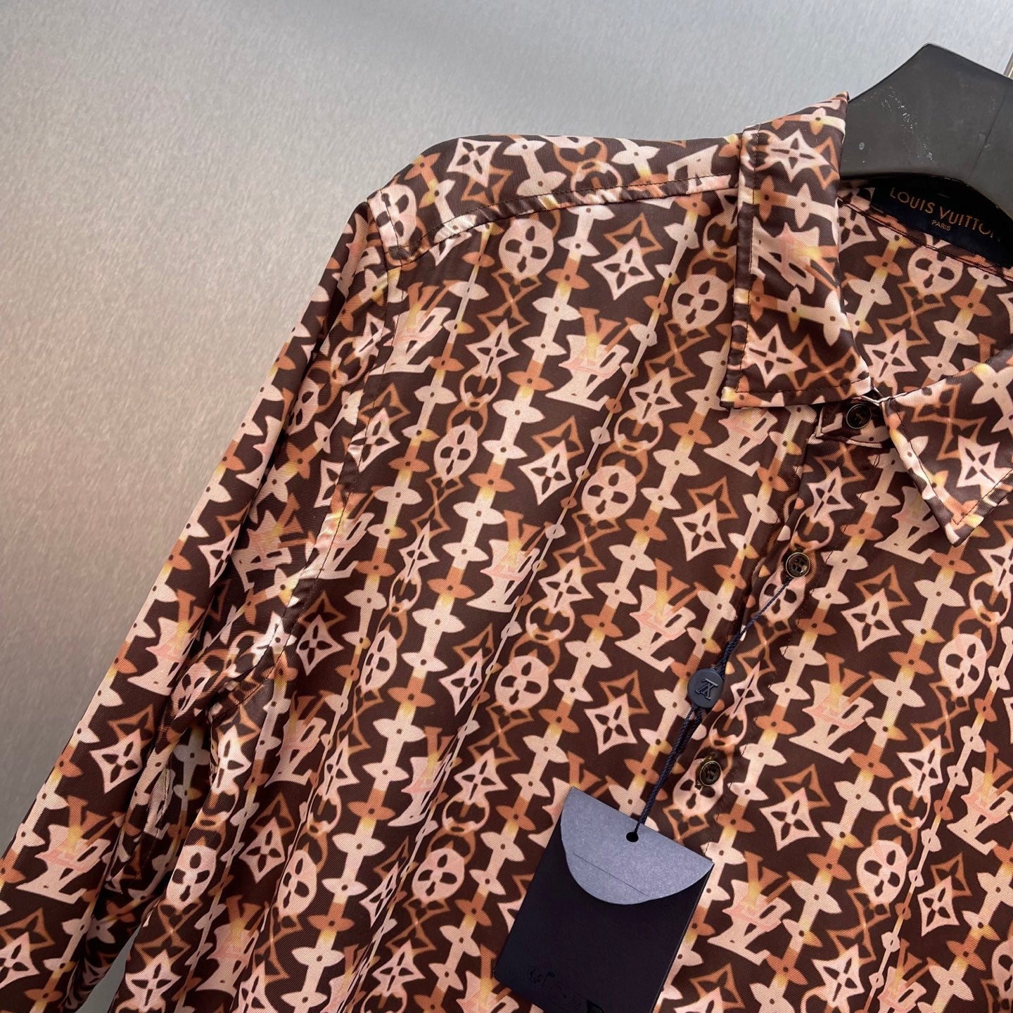Long-sleeve button-up shirt with brown-and-cream monogram pattern, button placket