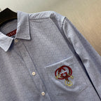 Light blue Gucci long-sleeve shirt with point collar and chest pocket, embroidered crest patch