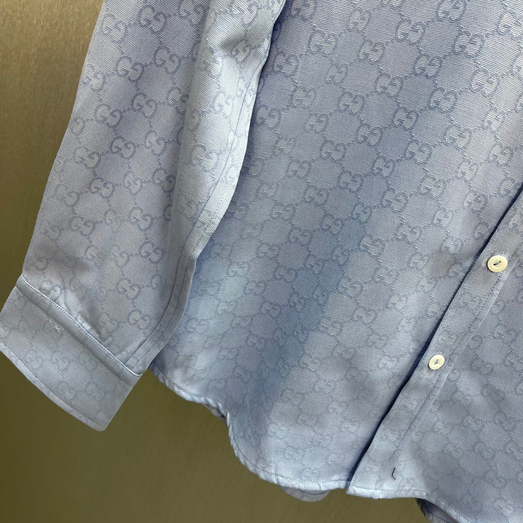 Light blue Gucci shirt with GG monogram pattern, buttoned cuffs and curved hem