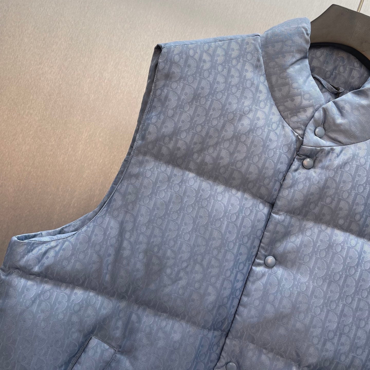 Light blue monogram puffer vest with button placket and patch pockets