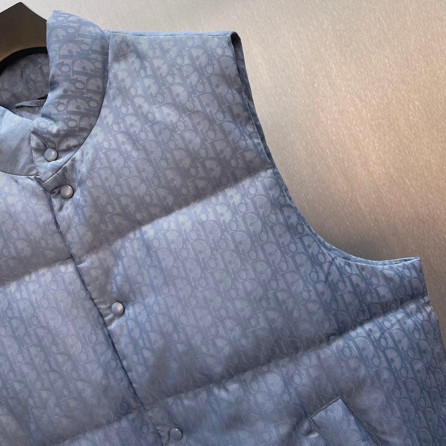 Light blue monogram quilted puffer vest with stand collar and button closure