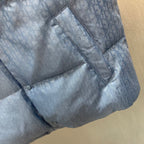 Light blue monogram puffer vest detail with seam stitching and button trim