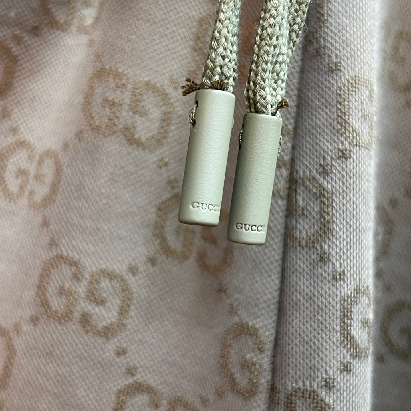 Gucci drawstring cords with metal tips on GG monogram shorts.