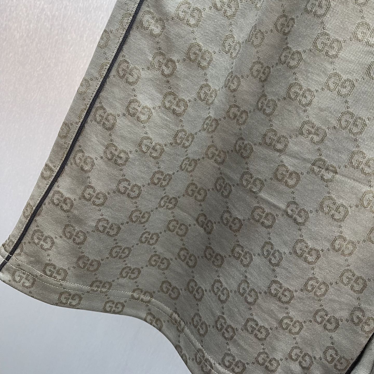 GG monogram shorts with textured fabric and curved hem detail, olive-brown.