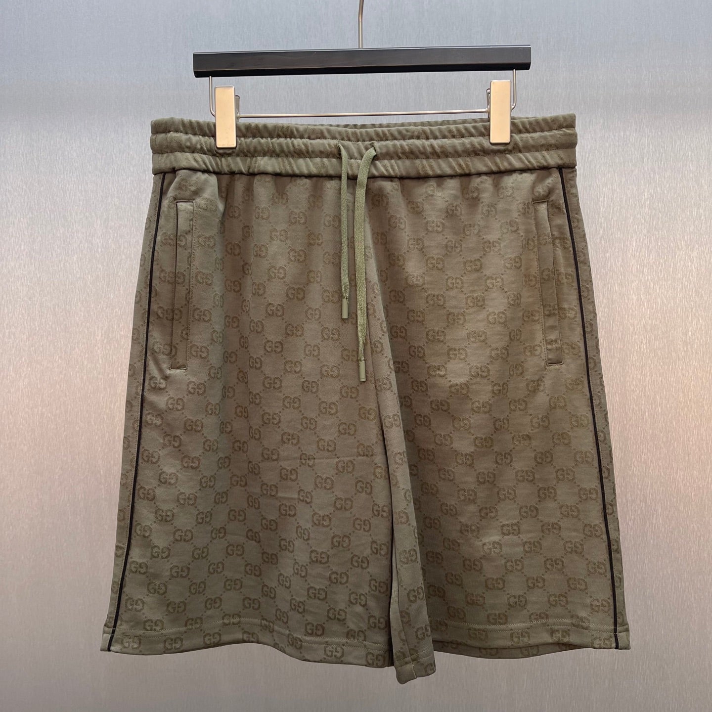 Men's drawstring shorts with GG monogram pattern and elastic waistband, olive-brown.
