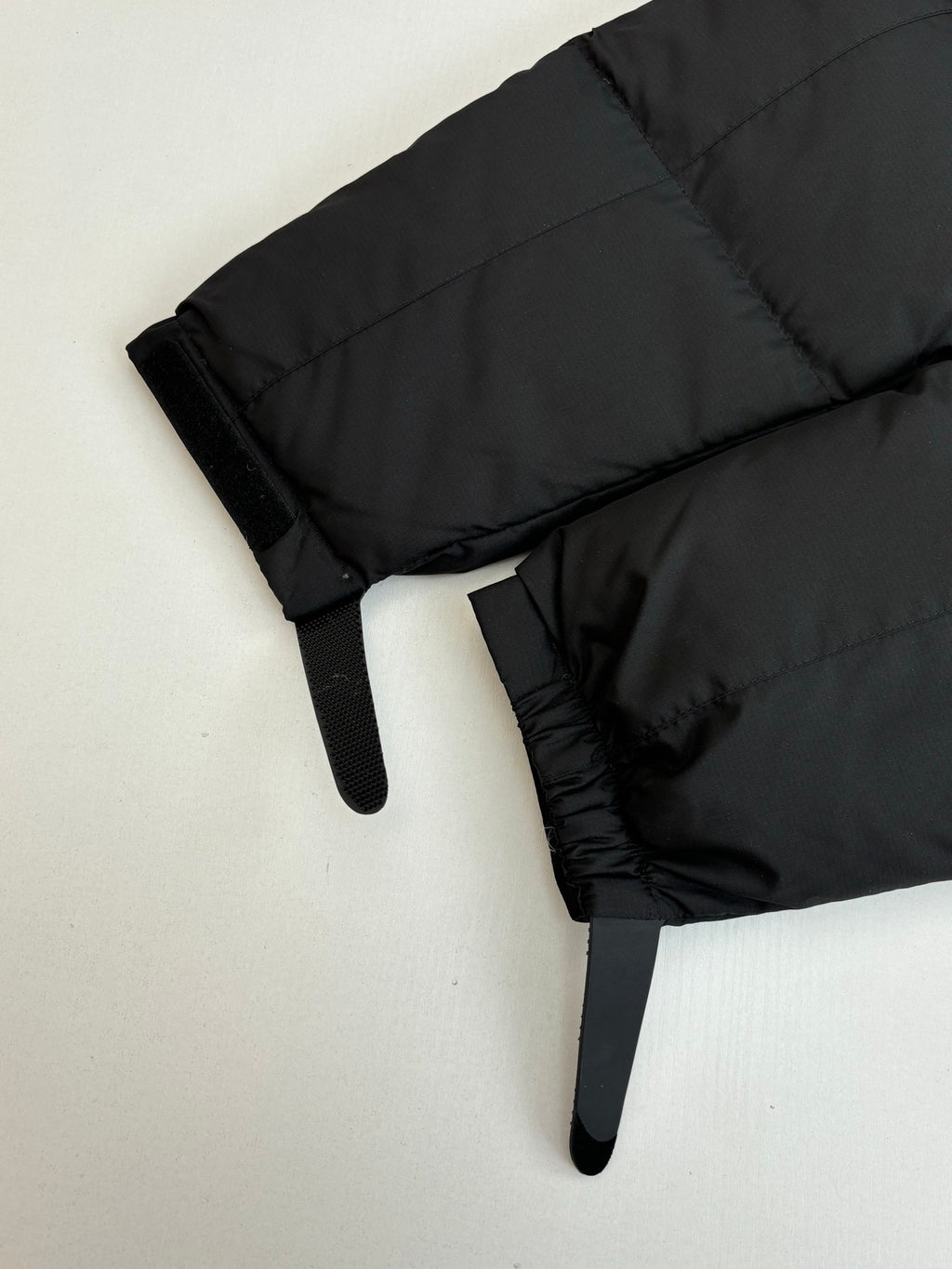 Black puffer jacket sleeve with elastic cuff and quilted stitching