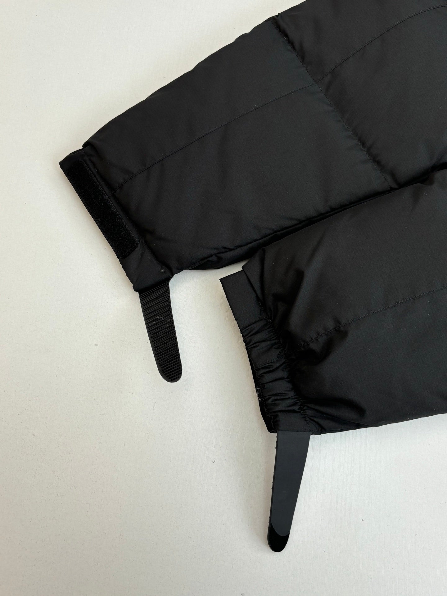 Black puffer jacket sleeve with elastic cuff and quilted stitching