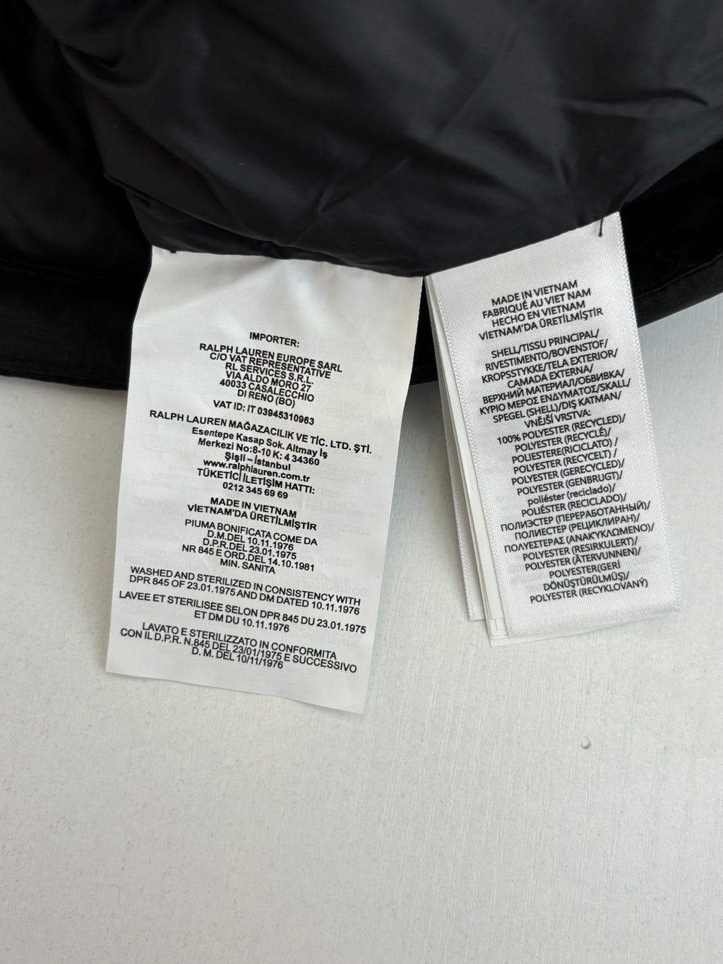 Inside Ralph Lauren puffer jacket care labels on white fabric tags