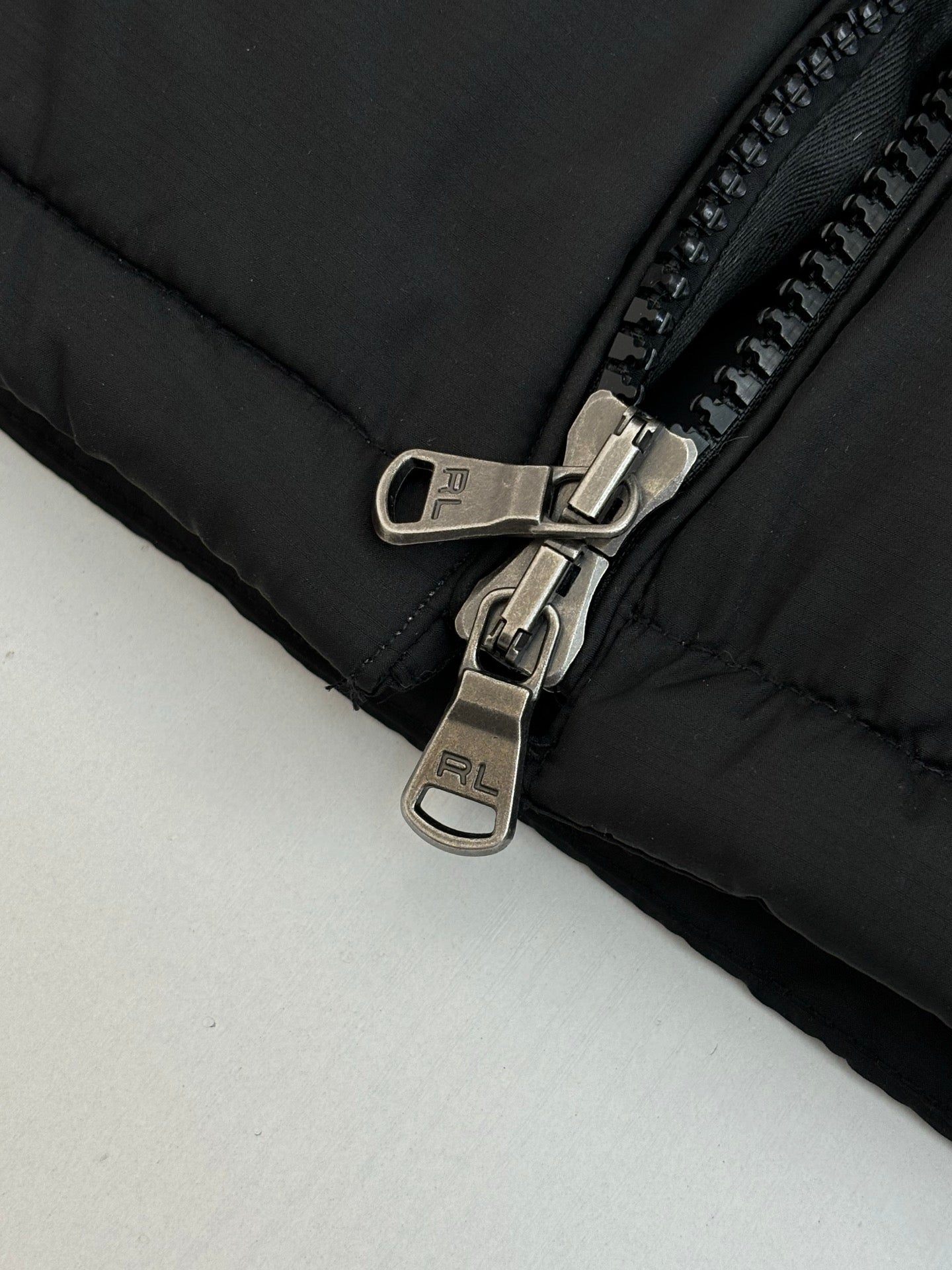 Ralph Lauren puffer jacket close-up of metal zipper pulls and quilted panel