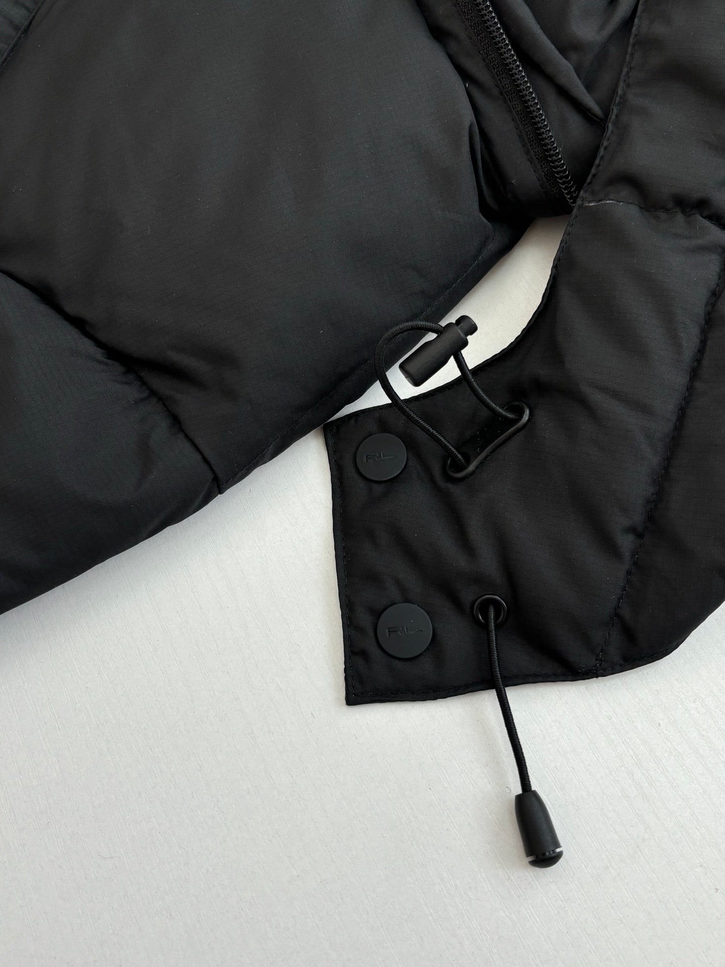 Ralph Lauren black puffer jacket cuff with snap tabs and hanging drawcord