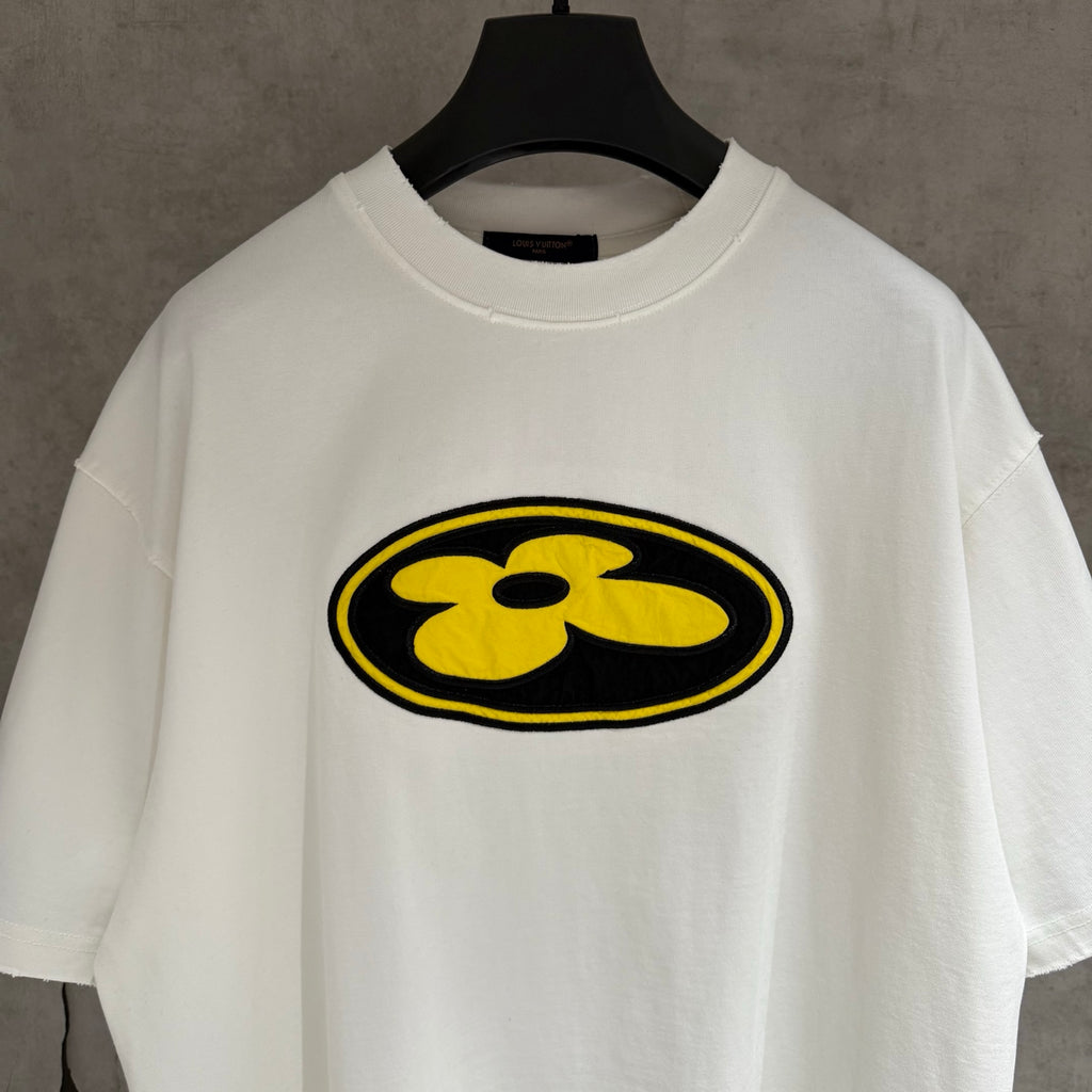 White short-sleeve T-shirt with large yellow flower emblem on the front