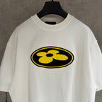 White short-sleeve T-shirt with large yellow flower emblem on the front