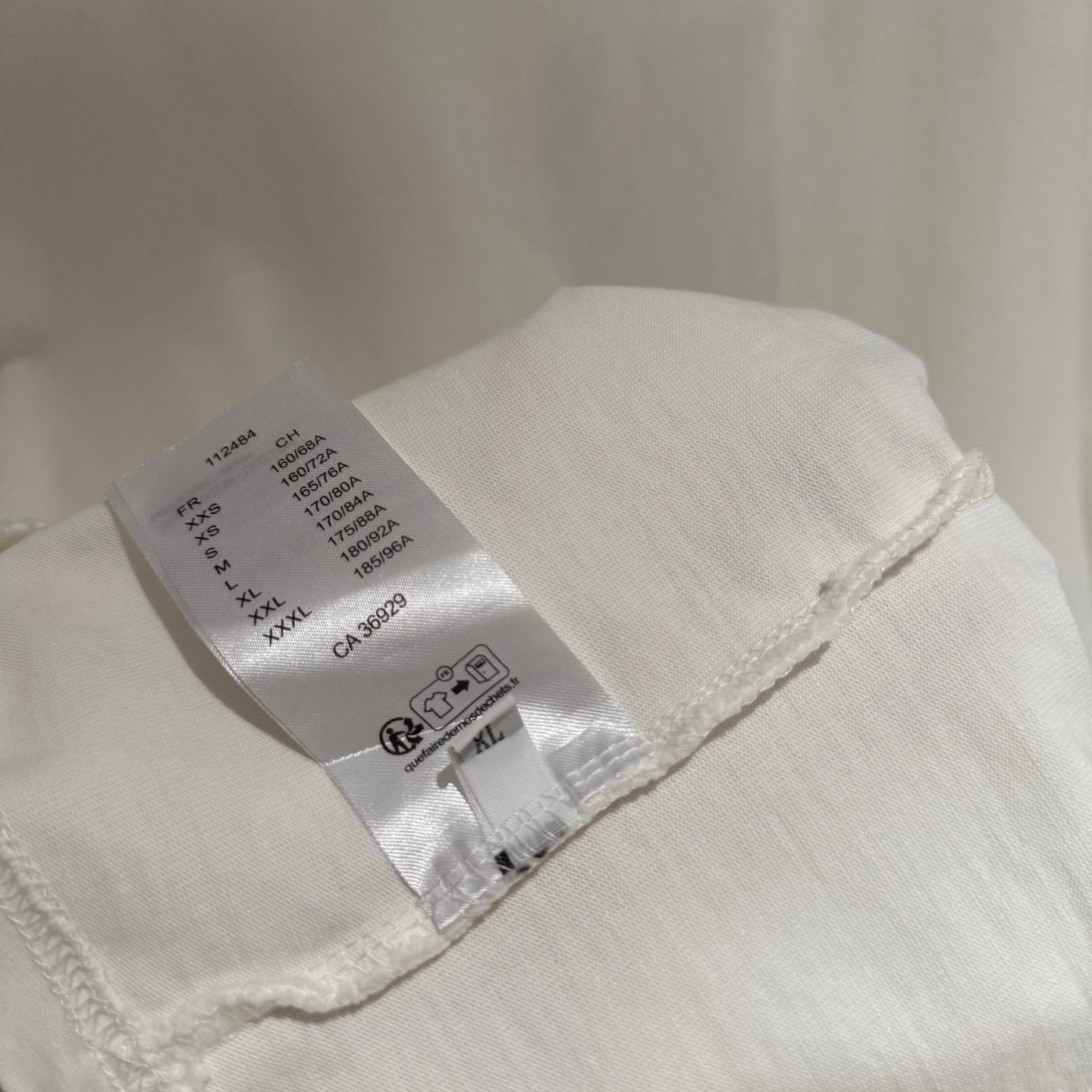 White short-sleeve T-shirt with fabric care label inside the hem