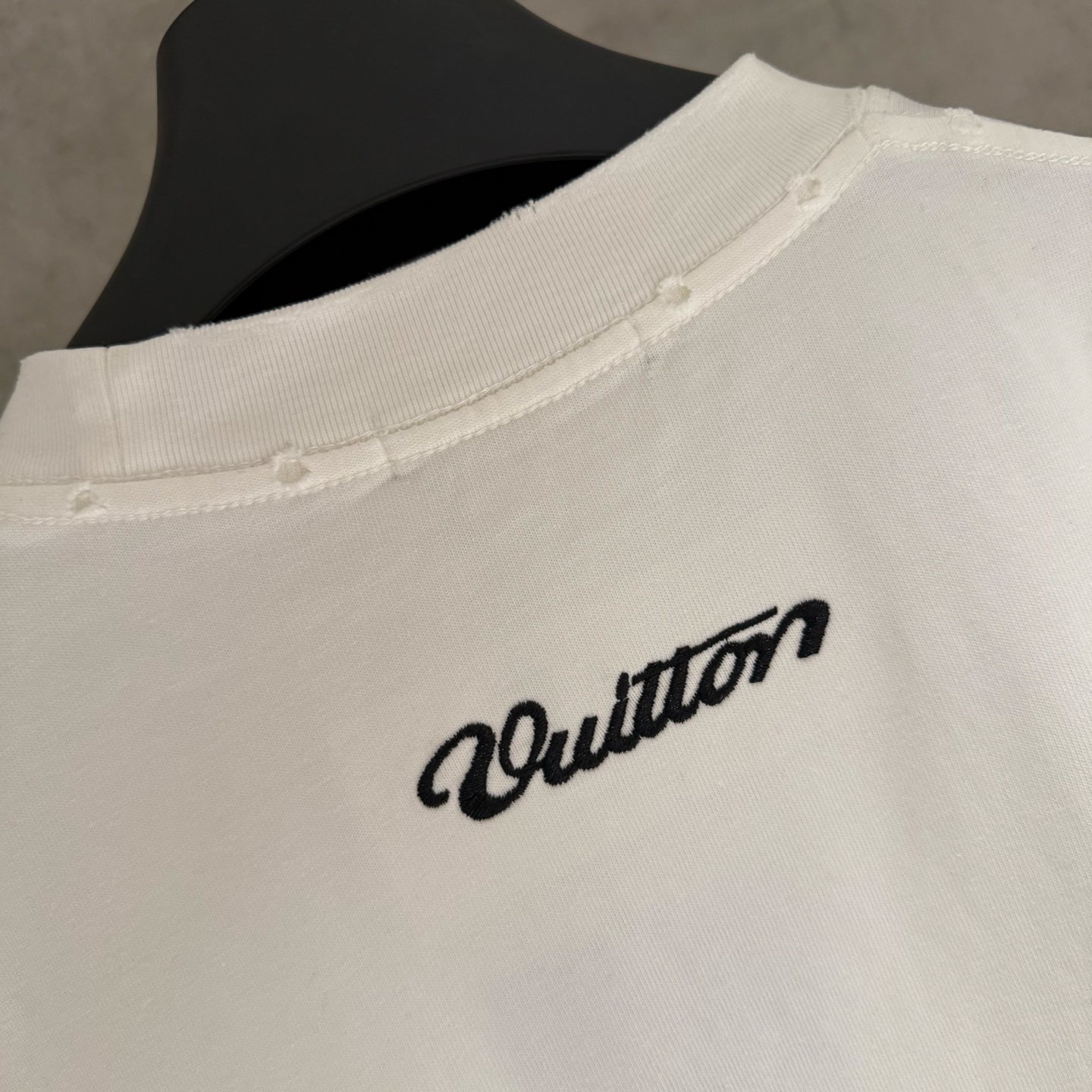 White short-sleeve T-shirt with Louis Vuitton script logo near the hem