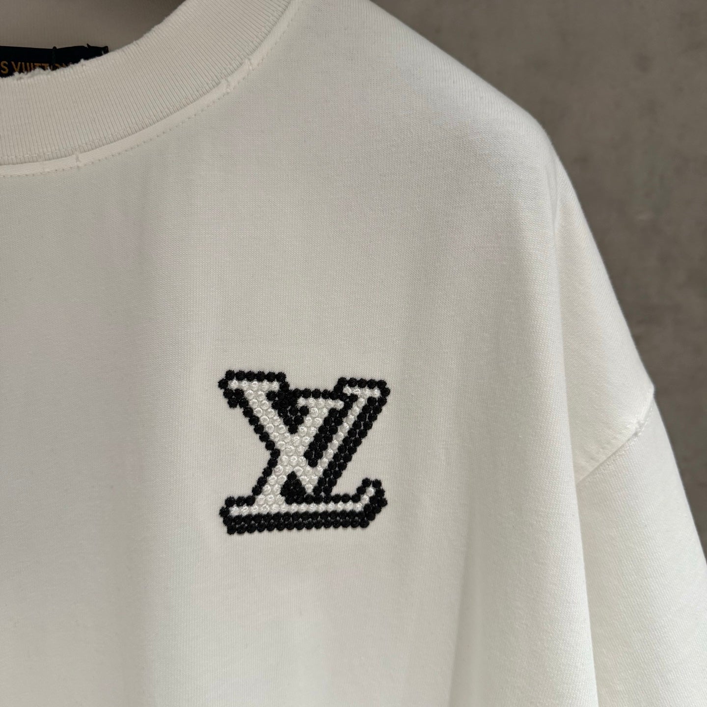 White short-sleeve T-shirt with black LV monogram patch logo on side