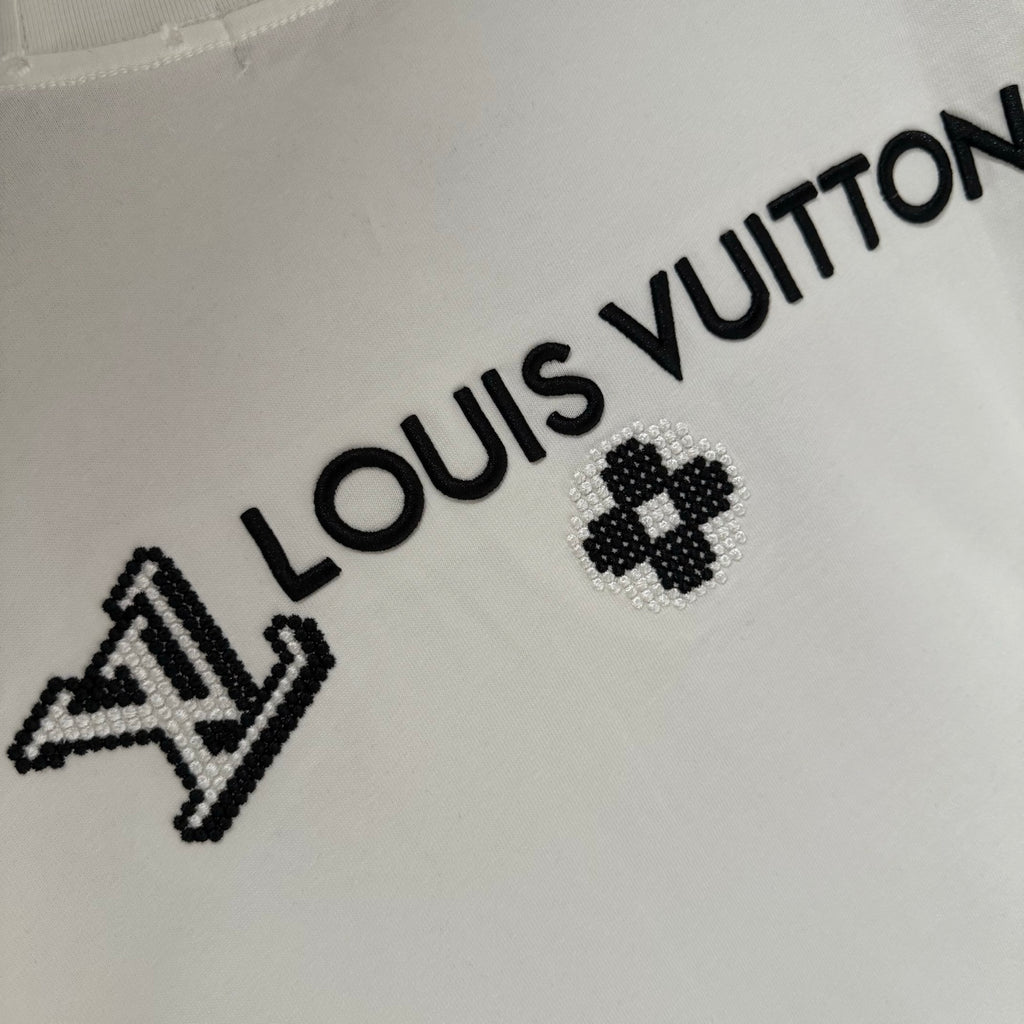 White T-shirt with black Louis Vuitton wordmark and clover emblem detail
