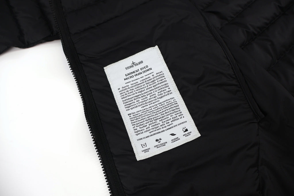 Stone Island puffer jacket care label on inner lining near zipper tape