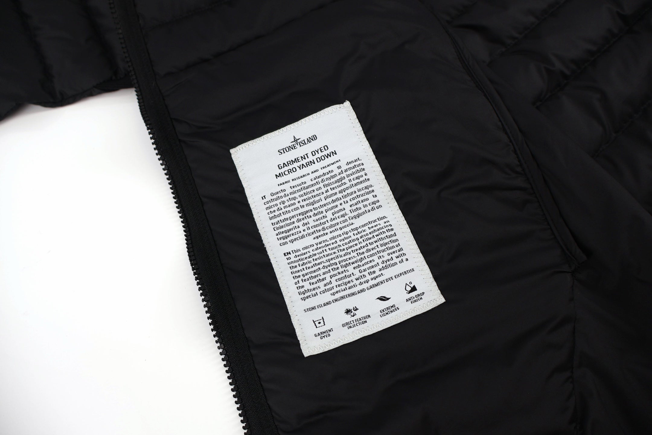 Stone Island puffer jacket care label on inner lining near zipper tape