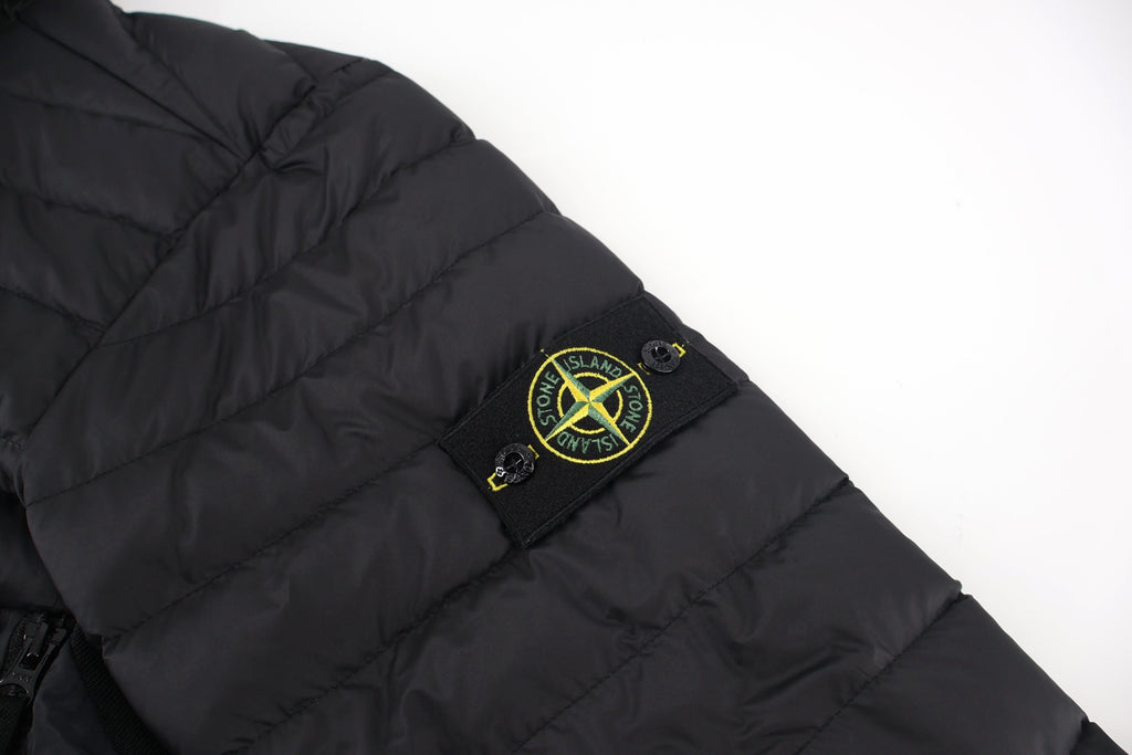 Stone Island logo patch on black puffer jacket sleeve