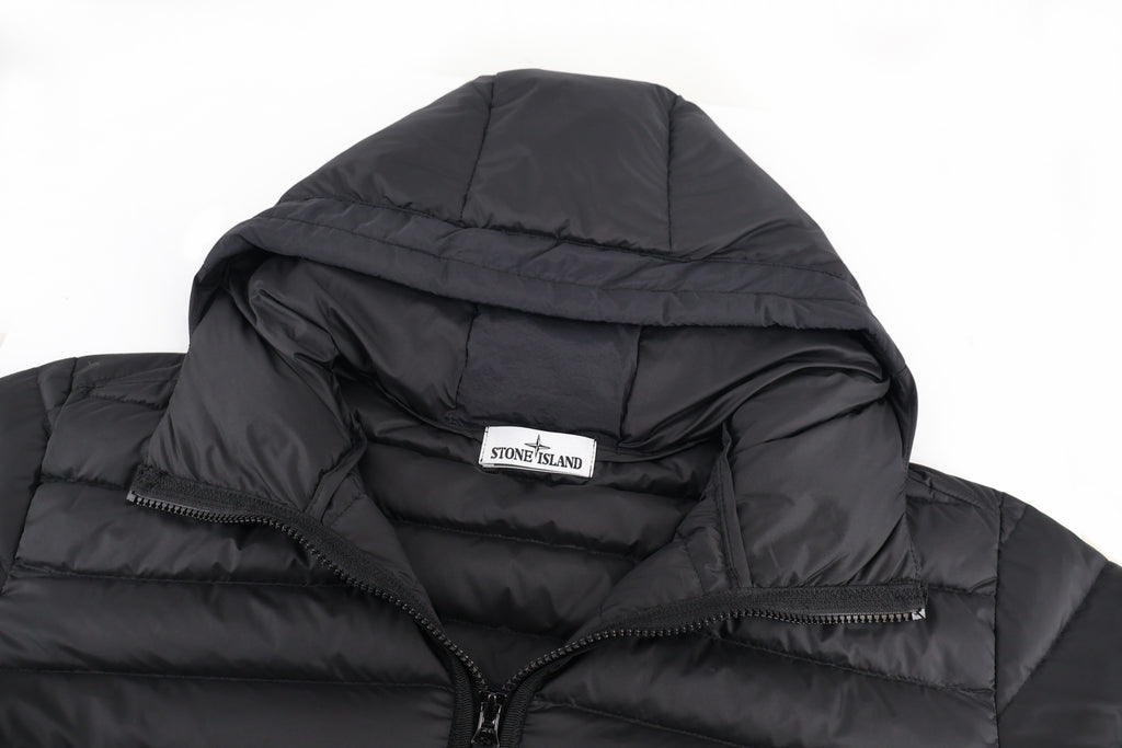 Stone Island puffer jacket hood close-up with chest logo label on black