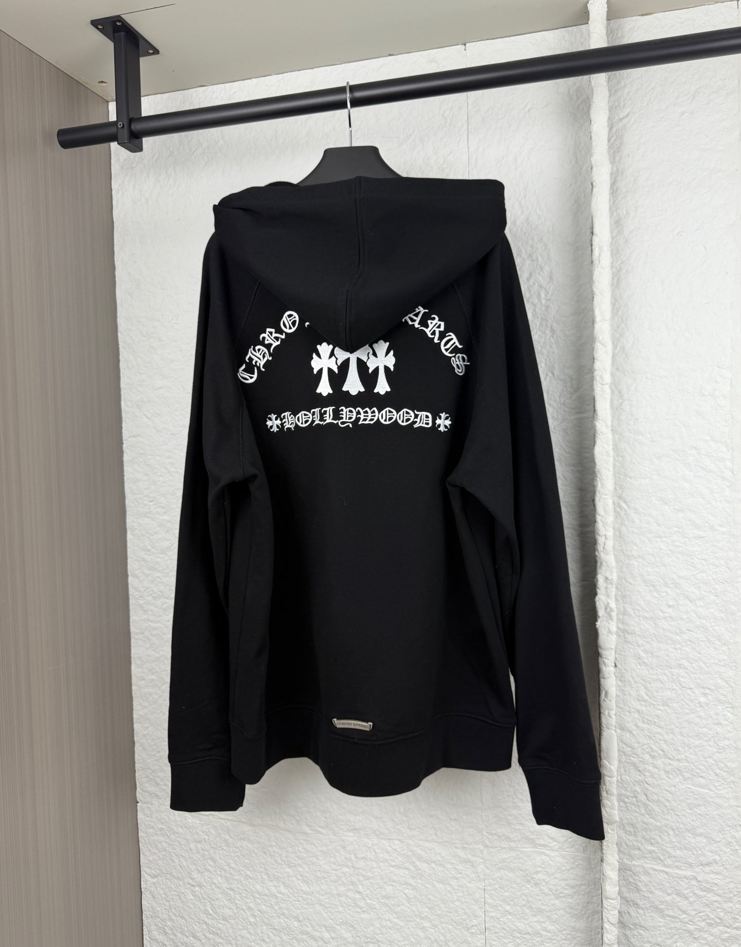Black hoodie back view with large white graphic and attached hood