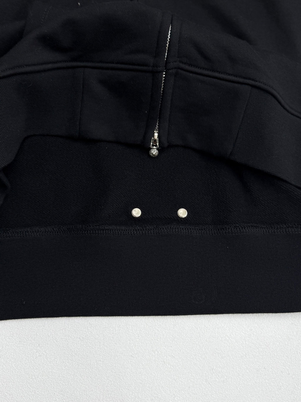 Black hoodie chest panel with zipper and two snap buttons