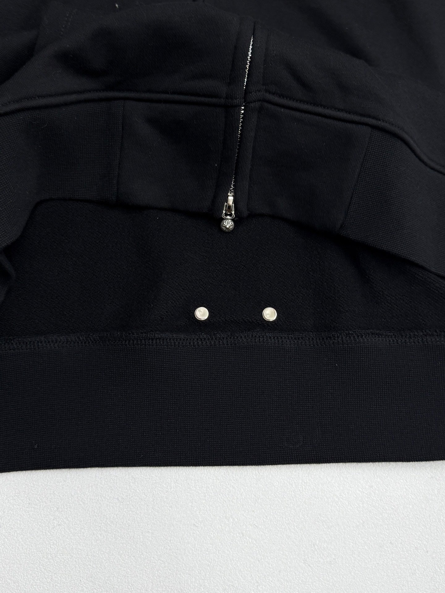 Black hoodie chest panel with zipper and two snap buttons