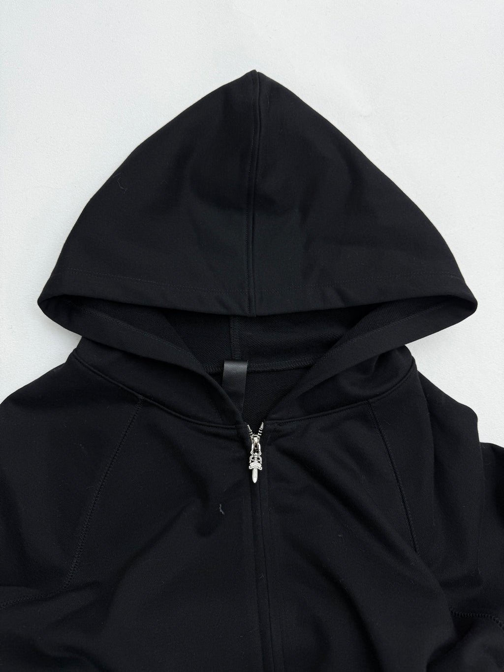 Black zip-up hoodie with drawstring hood and silver zipper detail