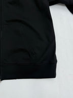 Black hoodie front pocket and hem detail with zipper closure